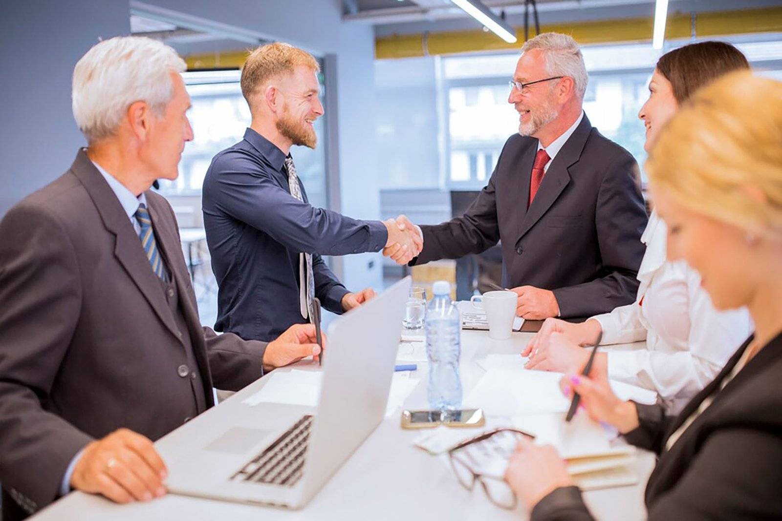 businesspeople looking two businessmen shaking hands business meeting 23 2147923365