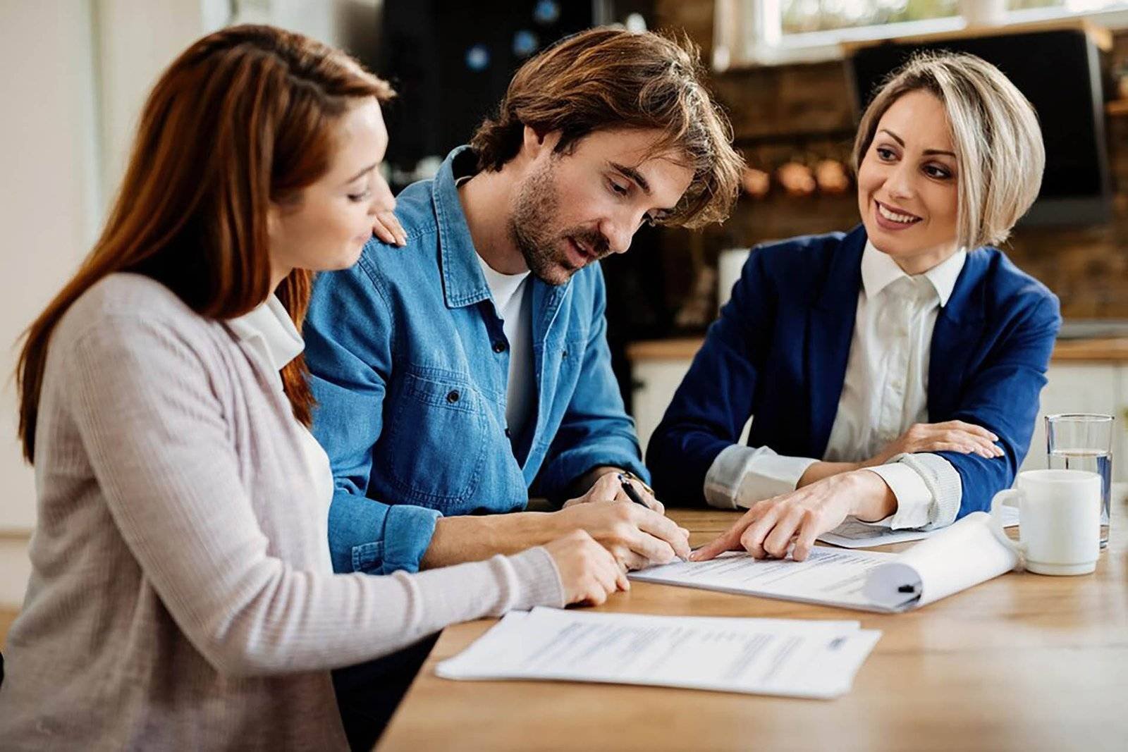 young couple signing lease agreement while having meeting with real estate agent focus is man 637285 3050